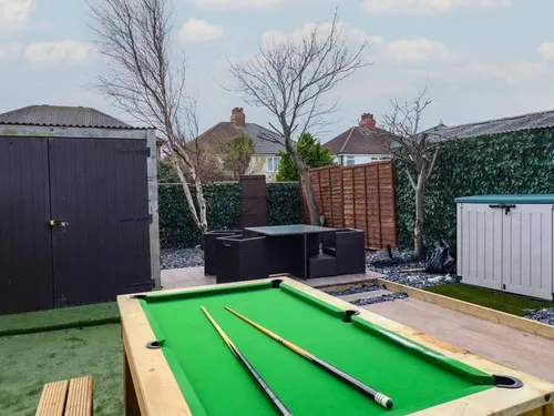 Cottage garden with pool table, outdoor seating, shed and storage unit