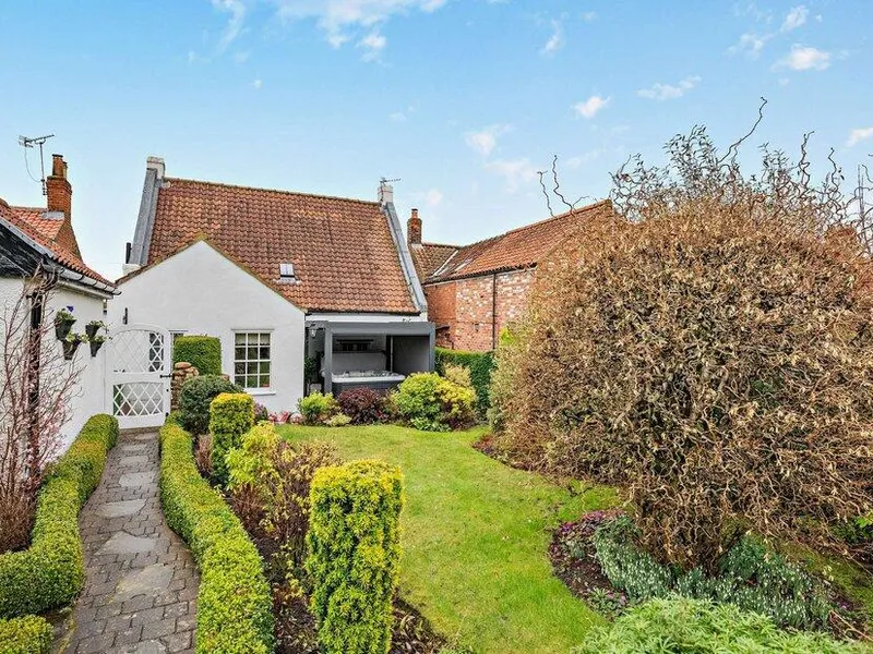3 Bed Cottage with red tile roof and landscaped front garden.