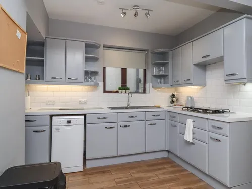 Cottage kitchen with grey cabinets, gas hob and built-in dishwasher