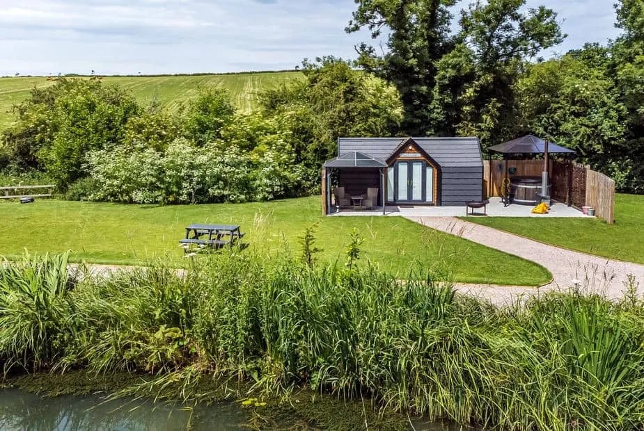 Acorn Lodge with outdoor hot tub, garden area and pond in a countryside setting