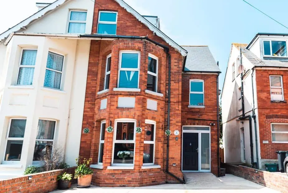 Anchor House red-brick exterior with bay window and potted plants at the entrance