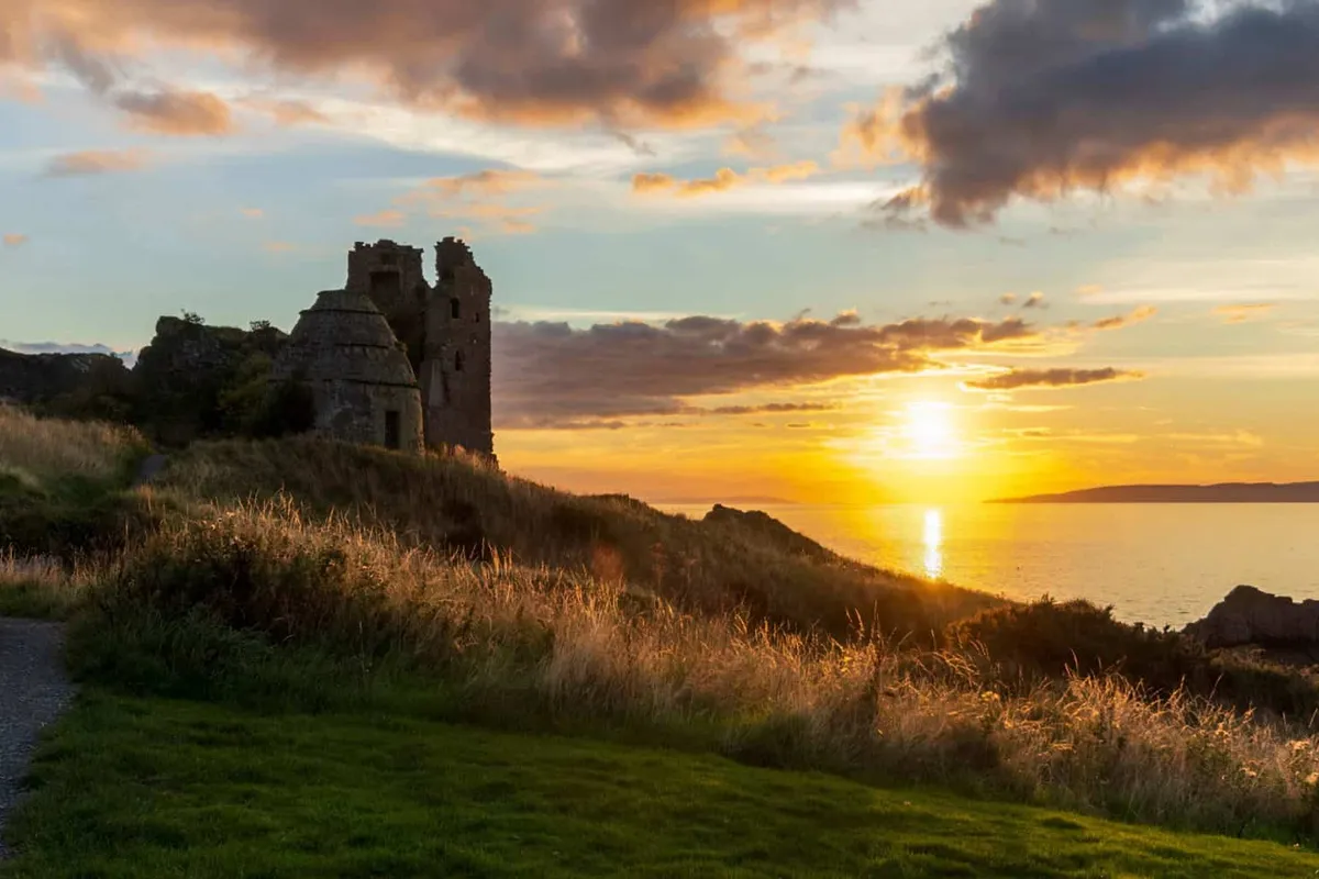 Sunset reflecting on the Firth of Clyde with the ruins of Dunure Castle in the foreground and the Isle of Arran in the distance.