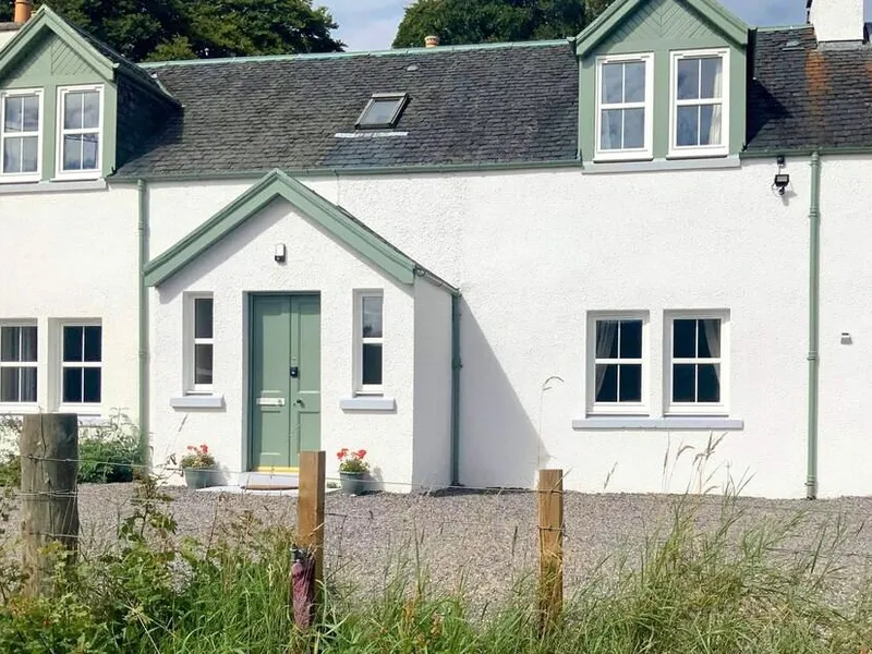 White-rendered Highland farmhouse with sage green front door and dormer windows