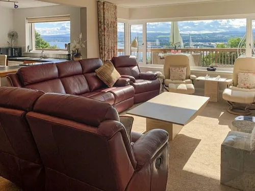Spacious living room with leather recliners and wide views across the Moray Firth through large windows