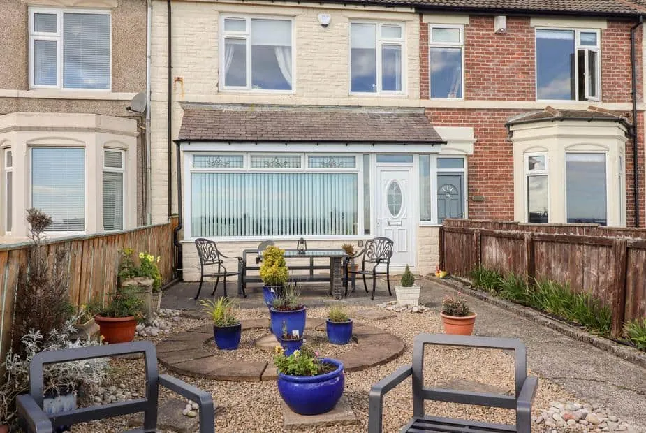 Beach Cove View outdoor patio with seating and potted plants in front garden