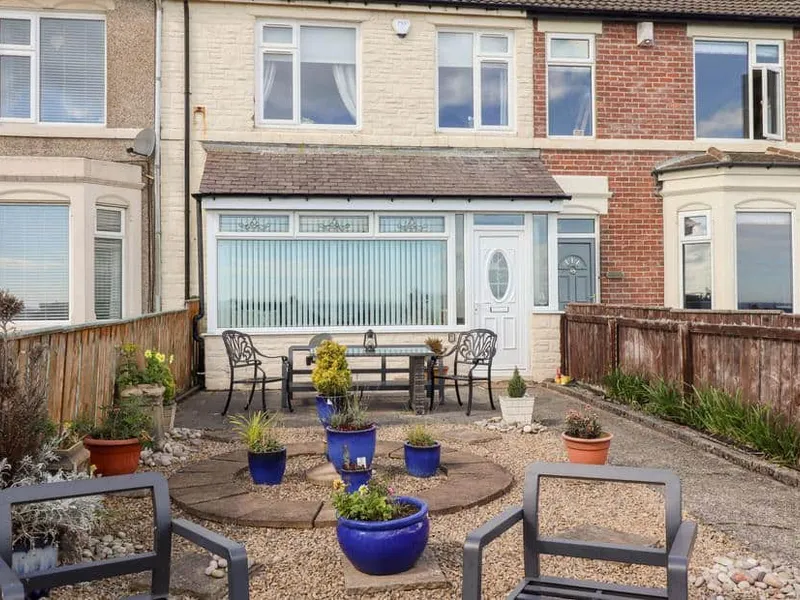 Beach Cove View outdoor patio with seating and potted plants in front garden