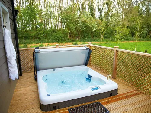 Lodge decking with hot tub and robe, overlooking garden and trees