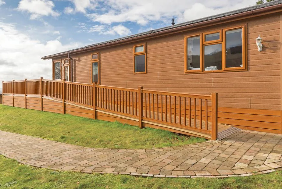 Cheddar Lodge Premier WF with ramped decking, wooden railings, and paved path