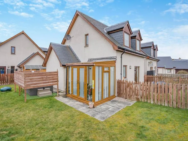 Clunnie Mor with sunroom and fenced garden on grass lawn