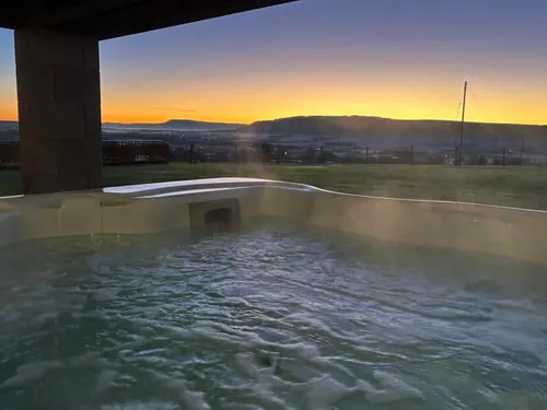 Cottage garden with hot tub overlooking fields at sunset