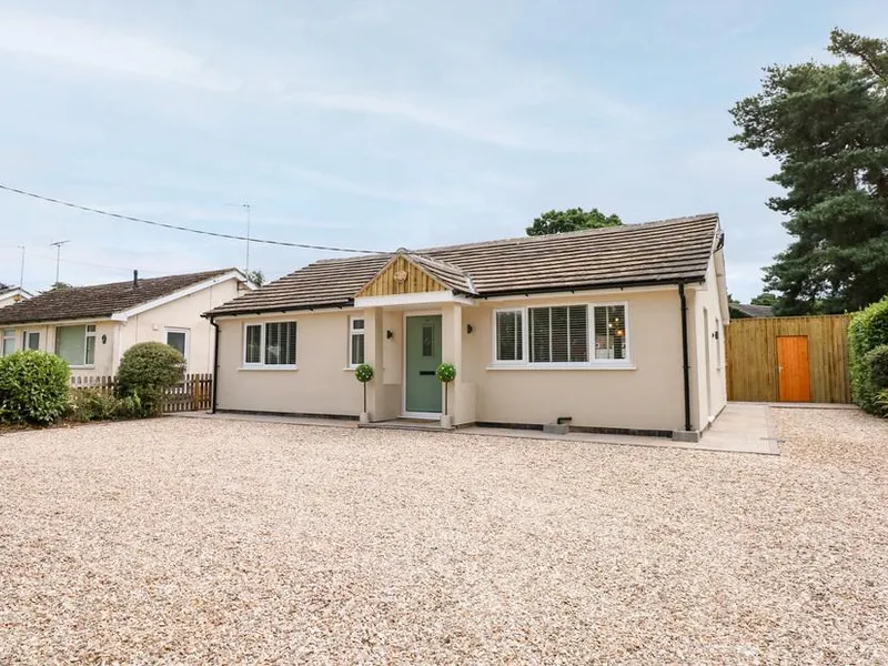 Daisy Tree Cottage with gravel driveway and light green front door
