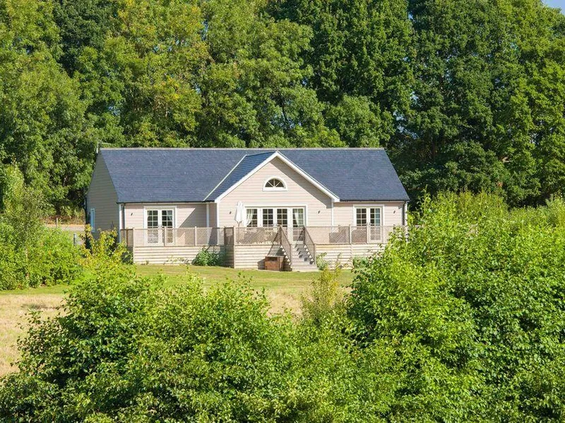 Endymion Lodge with large decking surrounded by trees and greenery