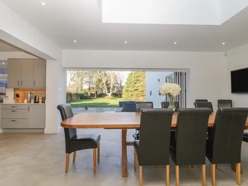 Stylish holiday home dining area with sliding doors opening to outdoor space.