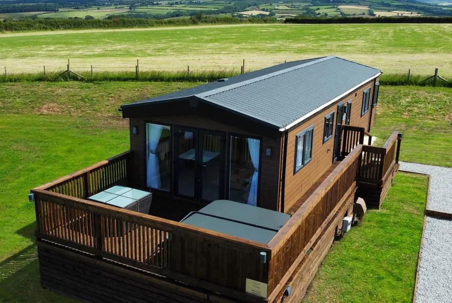 Hazel Lodge timber lodge with wraparound decking and hot tub set in open farmland near Whitby