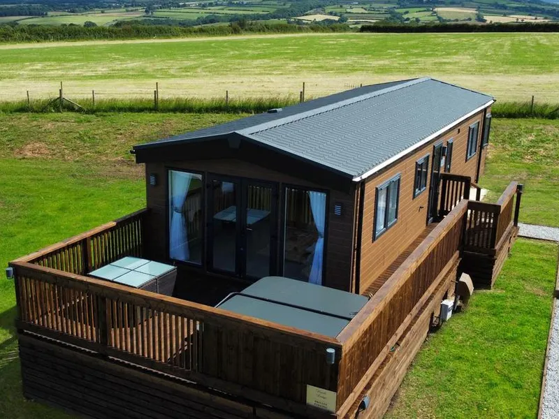 Hazel Lodge timber lodge with wraparound decking and hot tub set in open farmland near Whitby