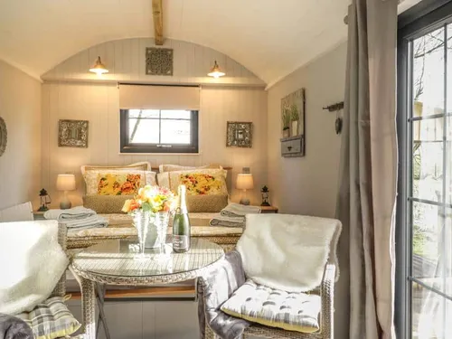 Lodge interior with double bed and small dining table by window