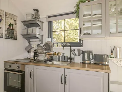 Lodge kitchen with oven, sink and grey cabinets under window