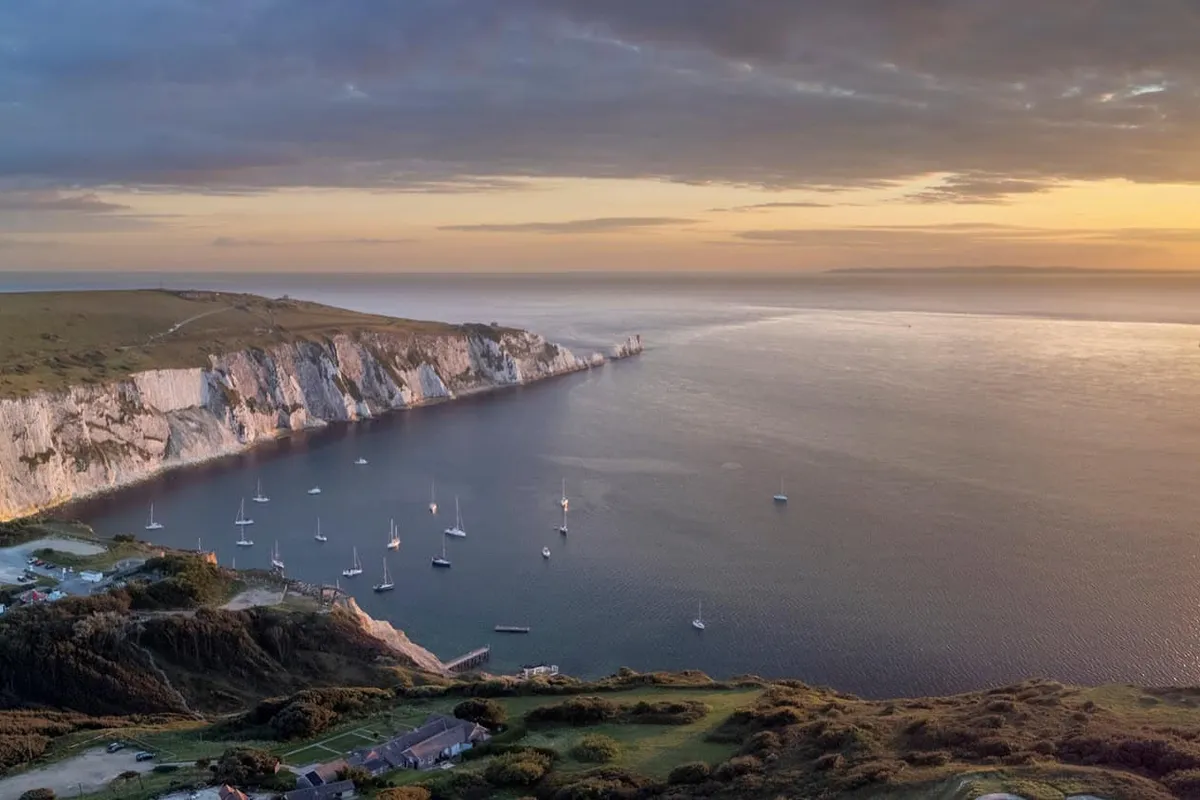 View across the famous coloured sand cliffs of Alum Bay towards The Needles sea stacks, Isle of Wight.