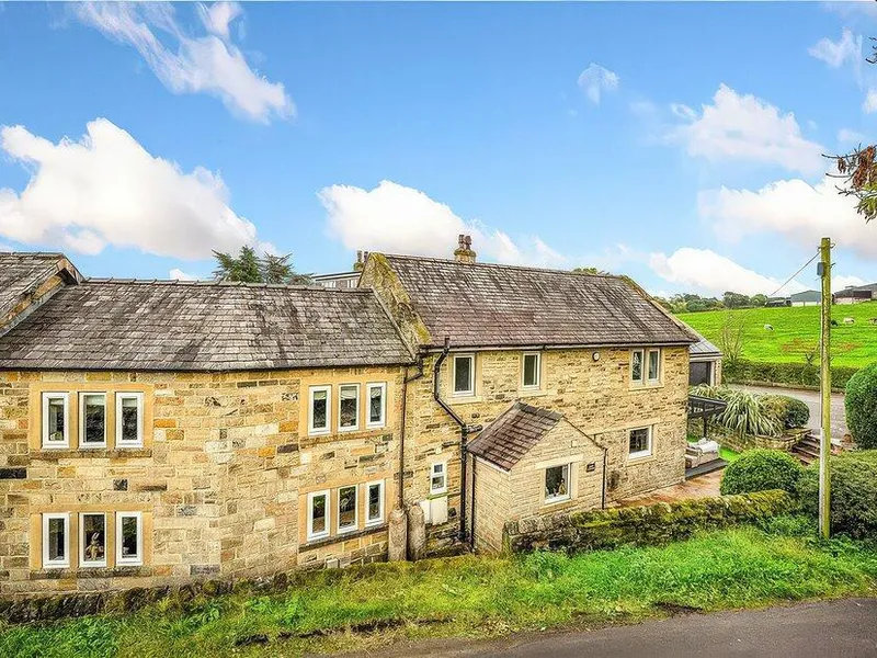 Johns Cottage honey stone exterior with slate roof and green fields rising behind near Hampsthwaite