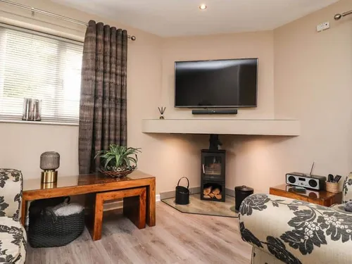 Lodge living room with wood-burning stove and wall-mounted TV