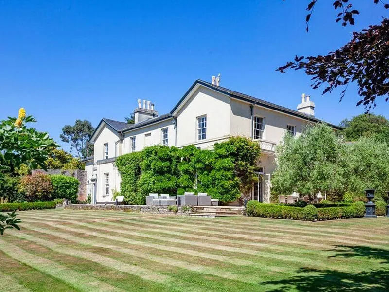 Laguna Mansion with outdoor seating overlooking a large striped lawn and gardens