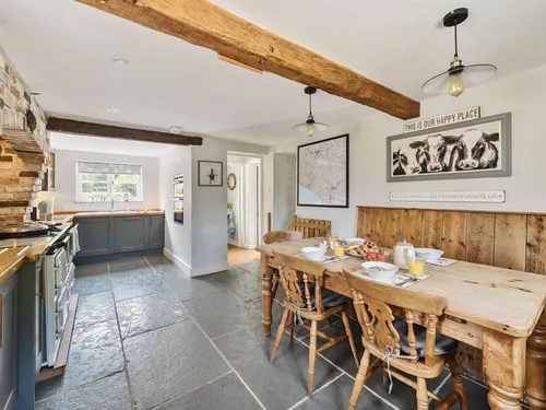 Cottage kitchen with wooden dining table and exposed ceiling beams