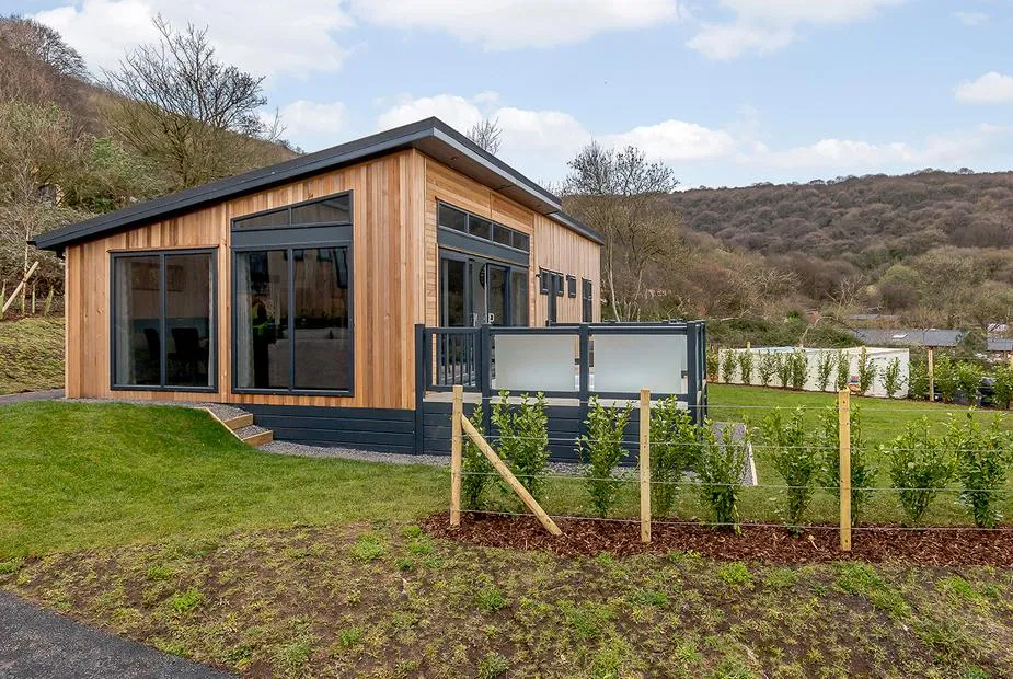 Langford Premier cedar-clad lodge with glass balcony on the Mendip hillside at Cheddar Woods