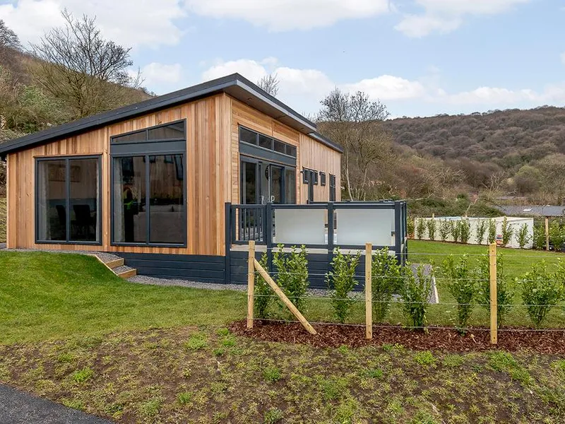 Langford Premier cedar-clad lodge with glass balcony on the Mendip hillside at Cheddar Woods