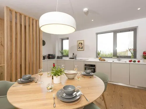Lodge kitchen with round dining table set for four and modern light fitting above