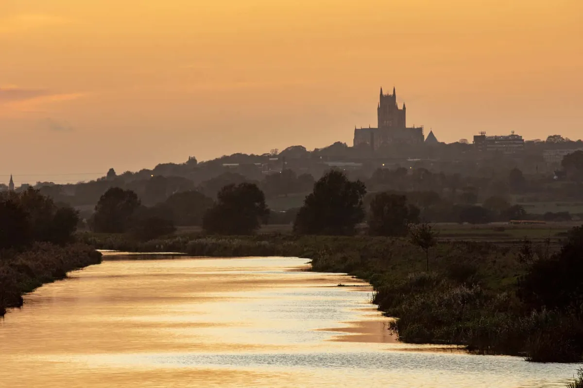 Golden sunset silhouette of Lincoln Cathedral sitting high on the hill overlooking the River Witham.