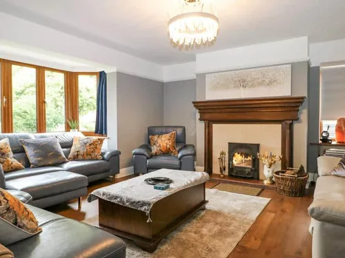 Cottage living room with sofas and wood-burning stove in fireplace