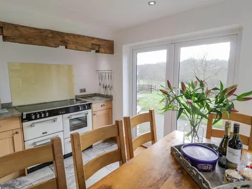 Cottage kitchen with range cooker and dining table by patio doors