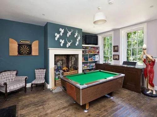 Cottage games room with pool table, dartboard and armchairs