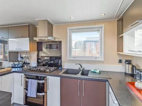 Lodge kitchen with gas hob, oven, and window above sink