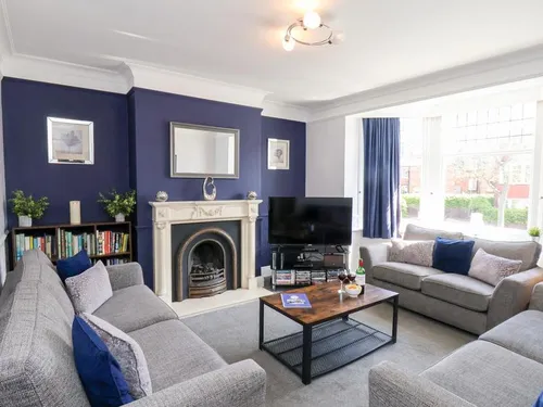 Living room with fireplace, sofas, television and large bay window