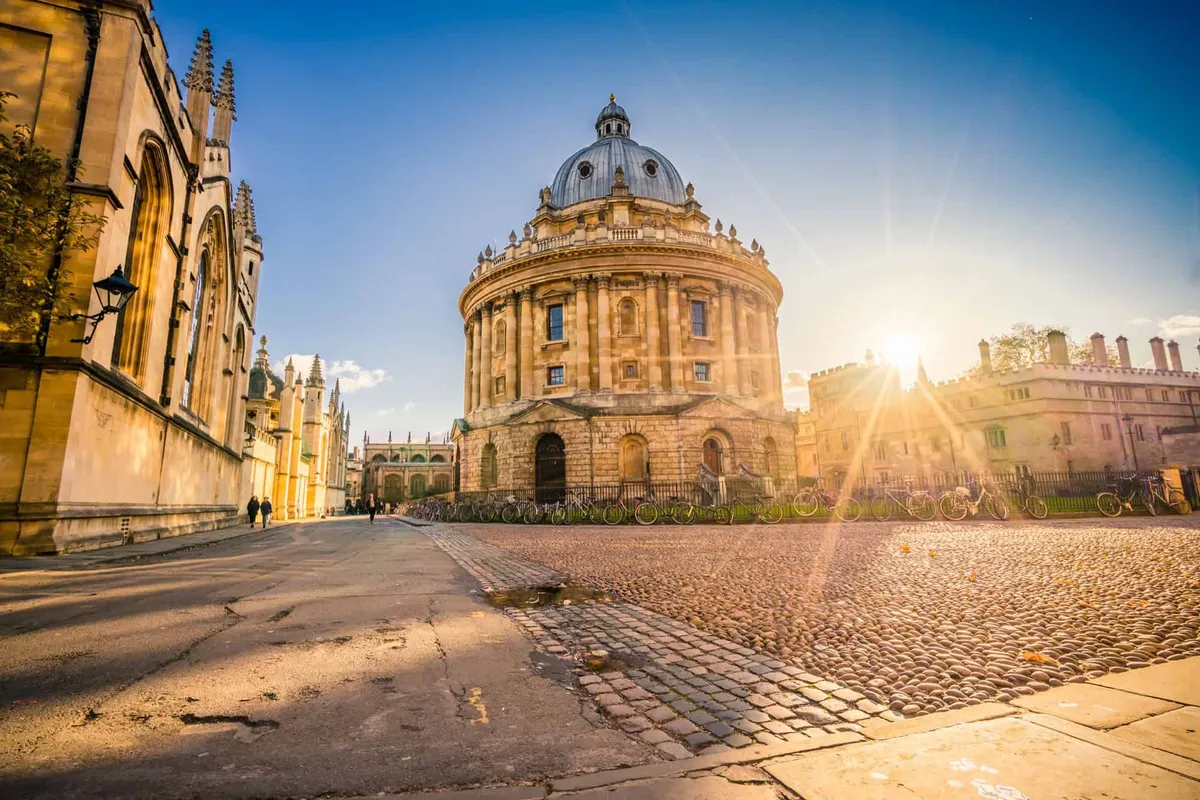 Sunburst shining over the historic Radcliffe Camera and cobblestone streets in Oxford.
