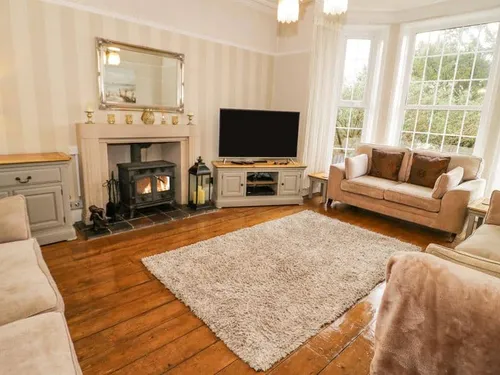 Living room with wood burner, sofas and bay window