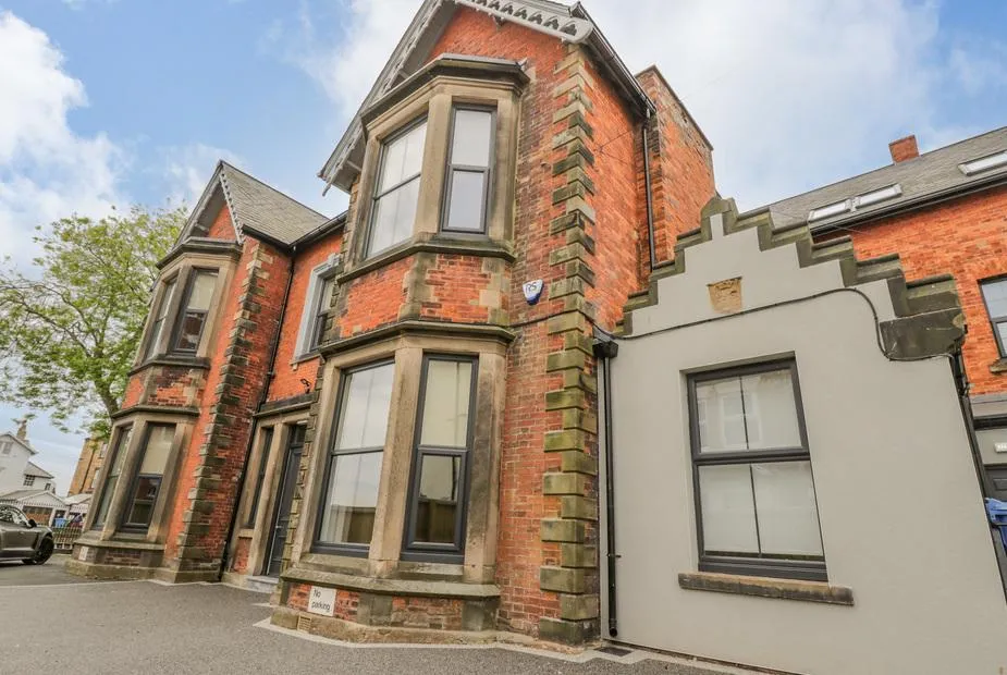 Railway House, a three-storey Victorian red-brick townhouse with bay windows and stone detailing