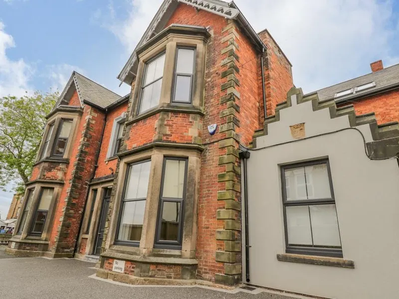 Railway House, a three-storey Victorian red-brick townhouse with bay windows and stone detailing