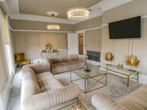 Ladies Lounge with plush velvet sofas, glass coffee tables, crystal chandeliers, and wall-mounted TV