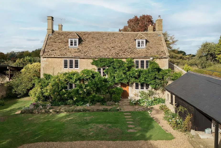 Reybridge House with stone exterior and climbing greenery overlooking a lawn garden