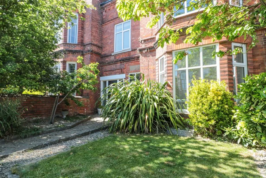Royal Victoria House red brick Victorian townhouse with white-framed bay windows and leafy front garden