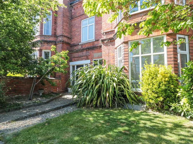 Royal Victoria House red brick Victorian townhouse with white-framed bay windows and leafy front garden