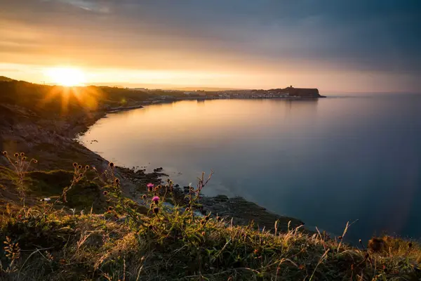 Warm sunset light over the sweeping curve of Scarborough's bay, viewed from the cliffs.