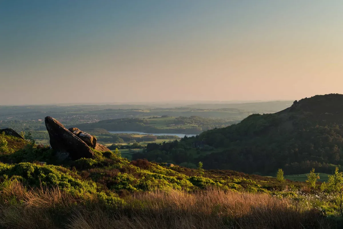 Sunset light illuminating the heather and rugged gritstone rocks at Ramshaw Rocks in the Staffordshire Moorlands.