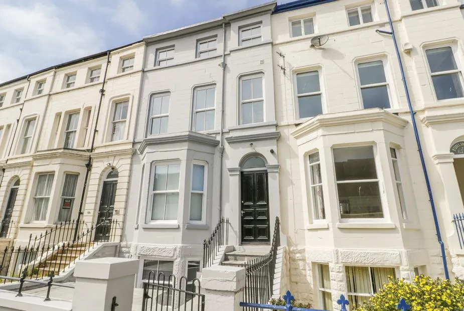 Station House Victorian terrace with arched doorway, iron railings, and bay windows on a Scarborough street
