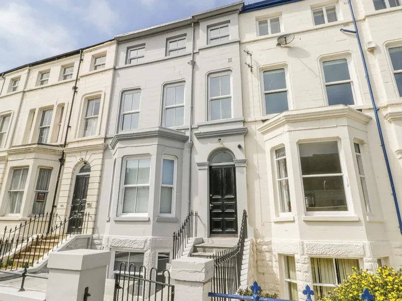 Station House Victorian terrace with arched doorway, iron railings, and bay windows on a Scarborough street