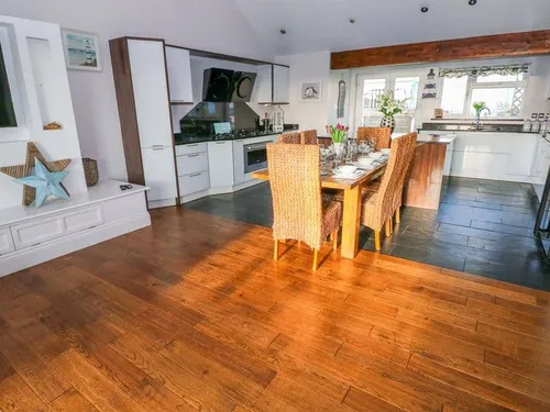 Cottage kitchen and dining area with wooden table and wicker chairs