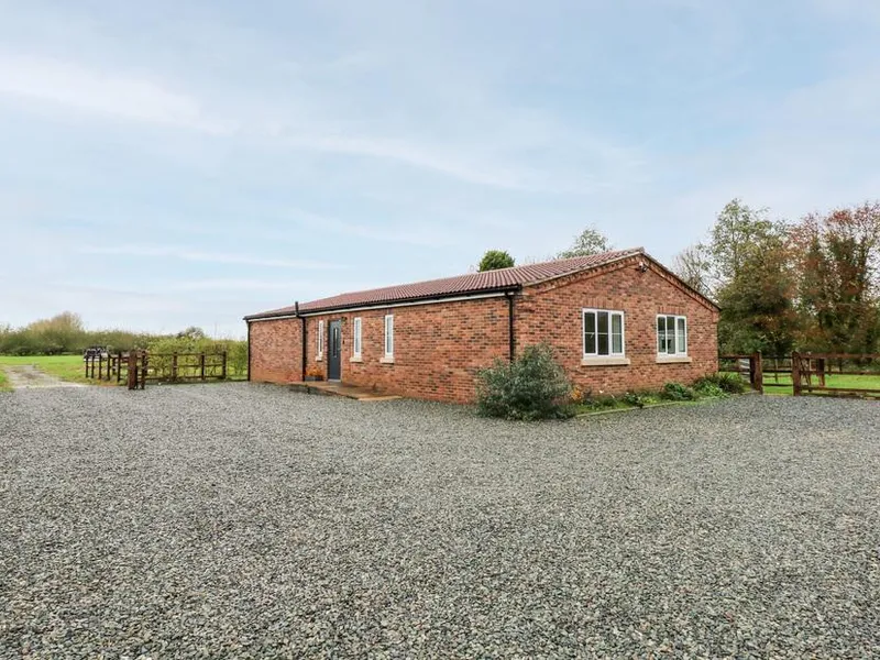 The Apple Shed brick cottage with gravel driveway and countryside views