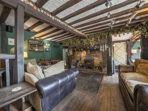 Cottage living room with exposed beams and log burner fireplace